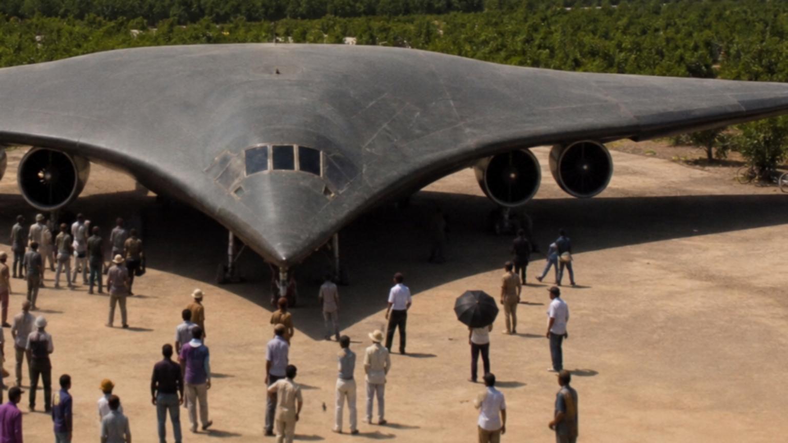 A colossal, wing-shaped aircraft with four roaring engines sits on …