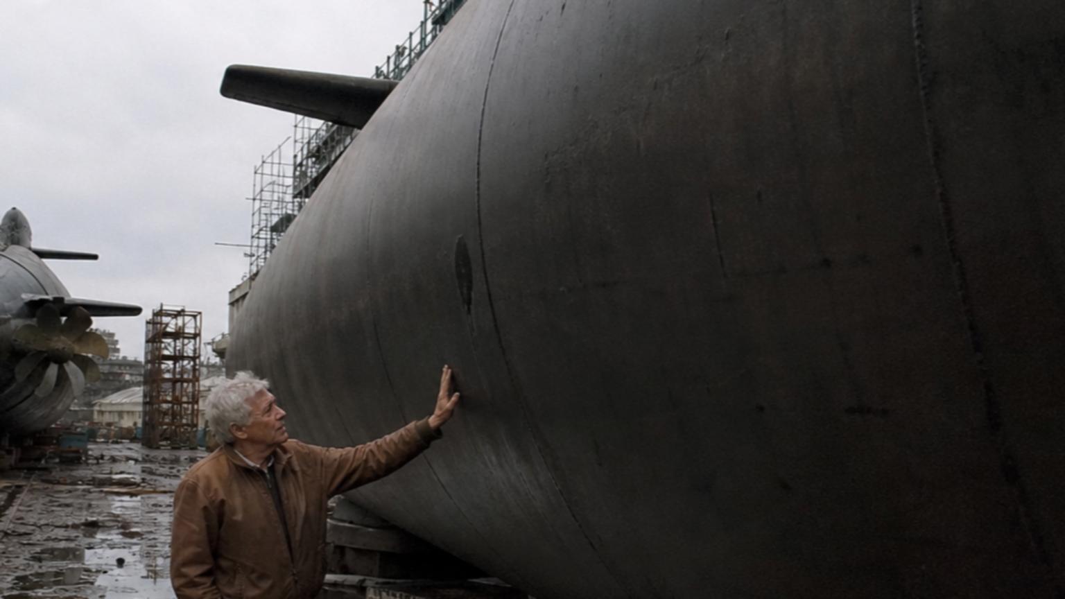 Amidst the towering industrial structures, a desolate shipyard stre…